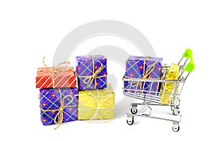 Boxes with gifts in bright packaging and shopping cart, preparation for the holidays, shopping