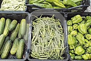 Boxes of green vegetables, cucumbers, beans and peppers photo