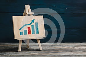 Boxes near easel with positive growth graphic, representing economic recovery