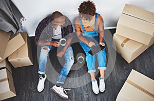 Boxes, new home and couple with a tablet planning on their living room floor together with coffee. Technology, real
