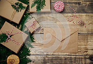 Boxes packed in kraft paper,branches on a wooden background. An envelope,letter of congratulations. Christmas,New Year