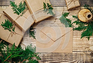 Boxes packed in kraft paper,branches on a wooden background.An envelope,a letter of congratulations.Christmas, New Year