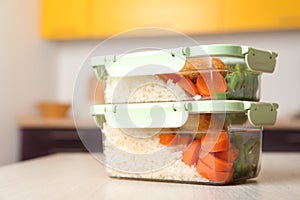 Boxes with prepared meals on table against blurred