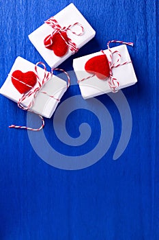 Boxes with presents with hearts  on   bright  blue textured  paper background.