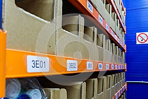 Boxes on racks in a warehouse of goods close-up.