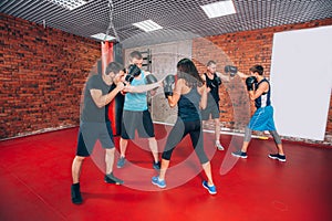 Boxing aerobox group with personal trainer man at