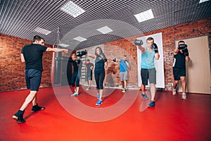 Boxing aerobox group with personal trainer man at