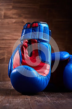 Boxing backgrounds with two blue and red gloves on the wooden plank.