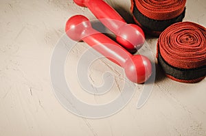 Boxing concept with red dumbbells and bandage/boxing concept with red dumbbells and bandage on a stone background. Copyspace