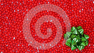 Boxing Day concept with space for text decorated with sparkling green bow against red color peppermint heart shaped candies