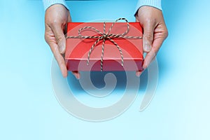 Boxing Day loading, young woman hand with a gift box offer to receiver