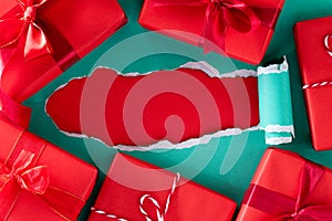 Boxing day Sale Online shopping. Top view of green pastel torn paper with red gift boxes