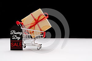 Boxing day sale, shopping cart and gift box with price tag