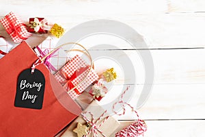 Boxing day Sale text on a black tag with shopping bag and gift box on a wooden white background. Online Shopping