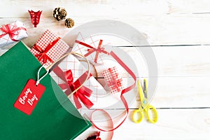 Boxing day Sale text on a black tag with shopping bag and gift box on a wooden white background. Online Shopping