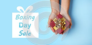 Boxing day sale. Top view of woman with gift on blue background, banner design