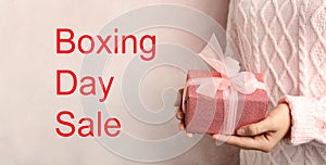 Boxing day sale. Woman with gift on background, banner design