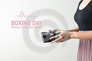 Boxing Day sale, young woman hold a gift box offer to receiver