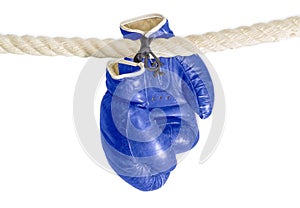 Boxing gloves hanging on the rope of a boxing ring