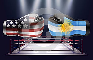 Boxing gloves with prints of the USA and Argentinian flags facing each other on a ring lit by spotlights