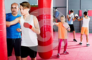 Boxing instructor and young children practicing blows