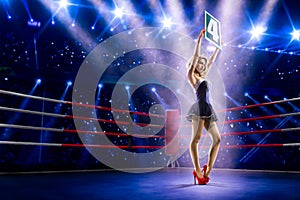 Boxing ring girl is holding the number