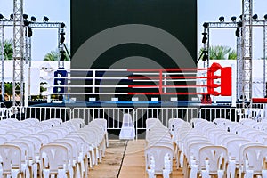 Boxing ring and many chairs for spectators prepared for competition, Outdoors. Sport and empty boxing ring in the city for a