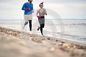 Boxing sparring man and woman running along beach together