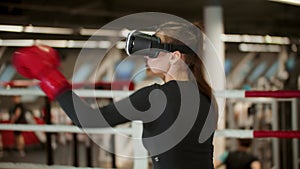 Boxing training - young woman trains her punches wearing VR glasses