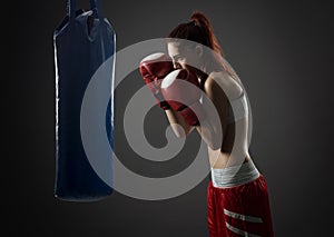 Boxing woman exercises with punching bag