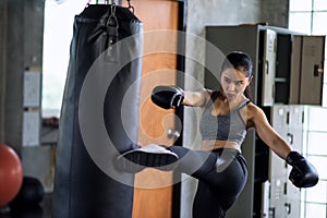 boxing woman kick huge punching bag in gym