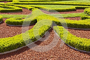 Boxwood hedges against trickling brick gravel paths.