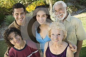 Boy (13-15) with parents and grandparents outside elevated view portrait.