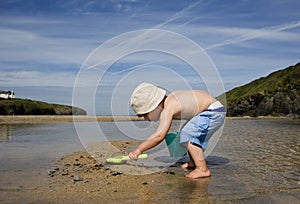 Boy (3-4) playing on beach back view