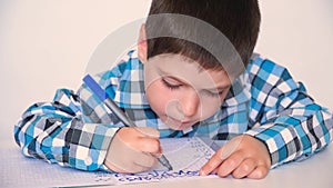 A boy of 4 years learns to write, writes copybook. Preparation for school for preschoolers