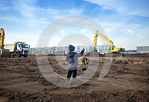 boy of 4 years old in warm clothes at a construction site
