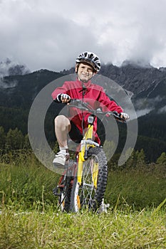 Boy (7-9) on bike in countryside portrait