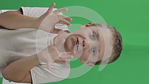 Boy of 9 years behaves very surprised. Green screen.Closeup
