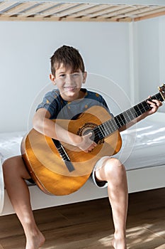Boy with acoustic guitar in his room