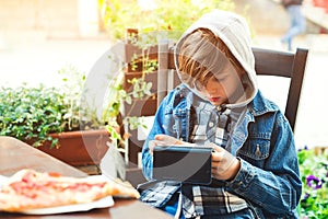 Boy addicted online games outdoors. Boy use phone and plays games. Schoolboy plays on smartphone after school