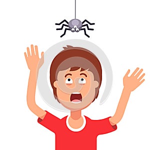 Boy afraid of a spider hanging from the top