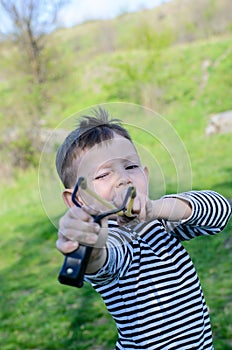 Boy Aiming Sling Shot at Camera