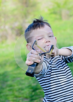 Boy Aiming Sling Shot at Camera