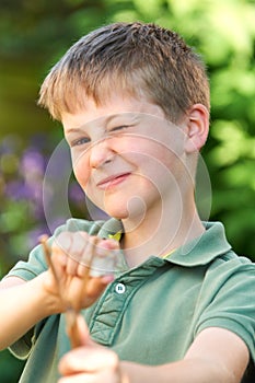 Boy Aiming Slingshot In Garden