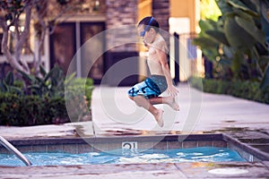 Chico en el aire saltando en piscina 