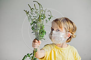 The boy is allergic to ragweed. In a medical mask, he holds a ra