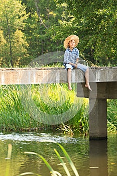 Boy during angling with rod on bridge