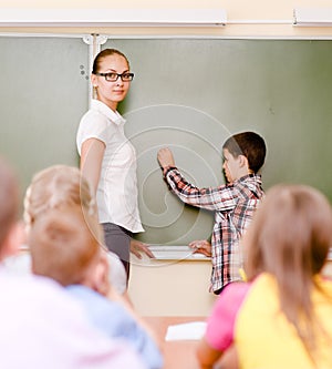 Boy answers questions of teachers near a school board