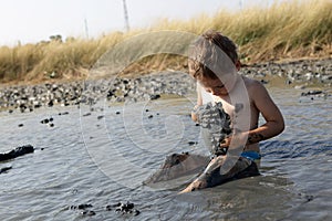 Boy applying black healing clay