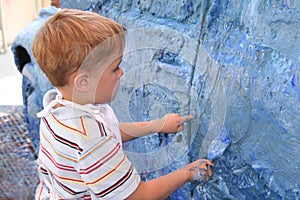 Boy artistically paint car